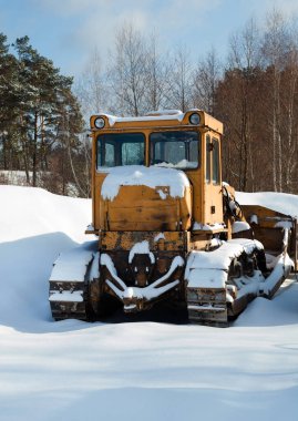 Kışın karda duran buldozer. Kar temizleme ekipmanları. Kar küreme (saban) makinesi.