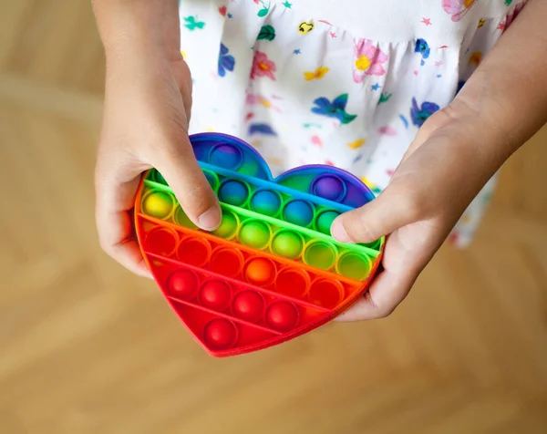 Flicka Håller Hjärtformade Regnbåge Pop Den Leksak Fidget Trendig Leksak — Stockfoto