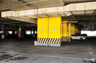 Binanın altına park etmek (otopark altı). Somut sütunlar.