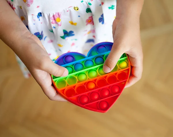 Girl Holding Heart Shaped Rainbow Pop Toy New Fidget Trendy — Stock Photo, Image