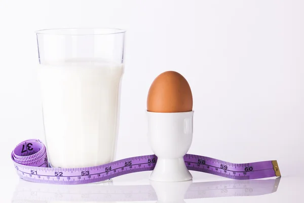 Glass of milk with boiled egg and tape — Stock Photo, Image