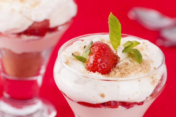 Two strawberry and cream desserts on red background — Stock Photo, Image