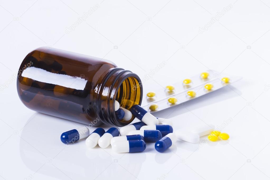 medicine bottle and tablets on white background