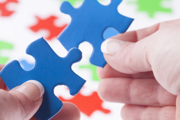 Woman hands fitting jigsaw puzzle pieces together — Stock Photo, Image