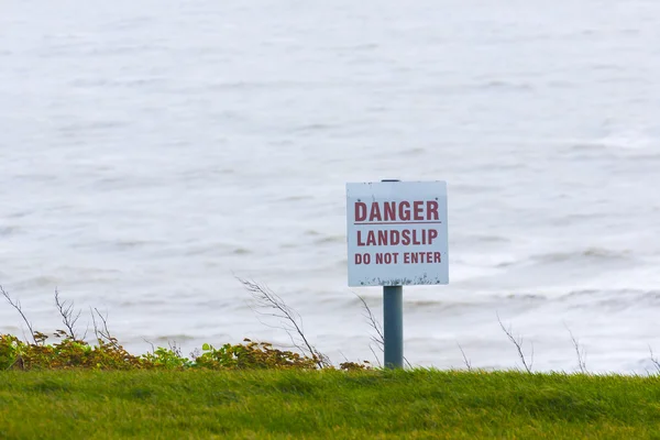 Sinal de perigo para sinal de informação pública ao lado do penhasco do mar — Fotografia de Stock