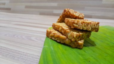 Ahşap zeminli muz yaprağında kızarmış tempeh.
