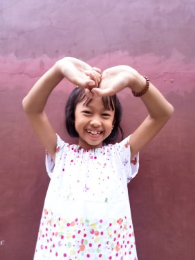 Güzel görünümlü, sevimli, sevimli, sevimli, neşeli, neşeli zeki küçük kızın portresi. Yeni bir fikir üretmek. İzole edilmiş koyu renk arka plan fantezisi.