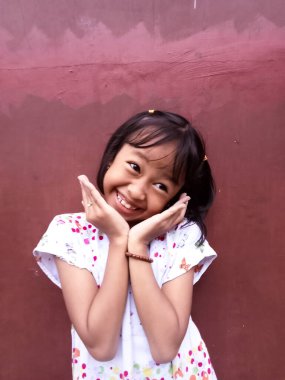 Güzel görünümlü, sevimli, sevimli, sevimli, neşeli, neşeli zeki küçük kızın portresi. Yeni bir fikir üretmek. İzole edilmiş koyu renk arka plan fantezisi.