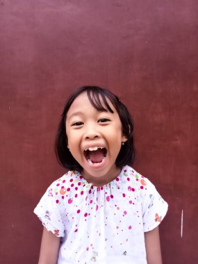 Güzel görünümlü, sevimli, sevimli, sevimli, neşeli, neşeli, zeki küçük kızın yeni bir çözüm üreten portresi izole edilmiş koyu kırmızı arka planı hayal et. Kameraya bak.