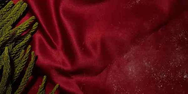 Fotokopi alanını karşılamak için soyut kırmızı kumaş ve çam yaprakları arka plan