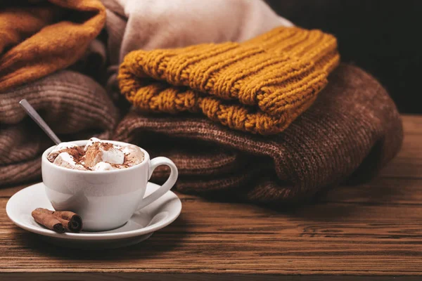 Cup of cacao and pile of knitwear — Stock Photo, Image