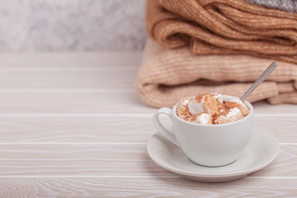 Cup of cacao and pile of knitwear — Stock Photo, Image