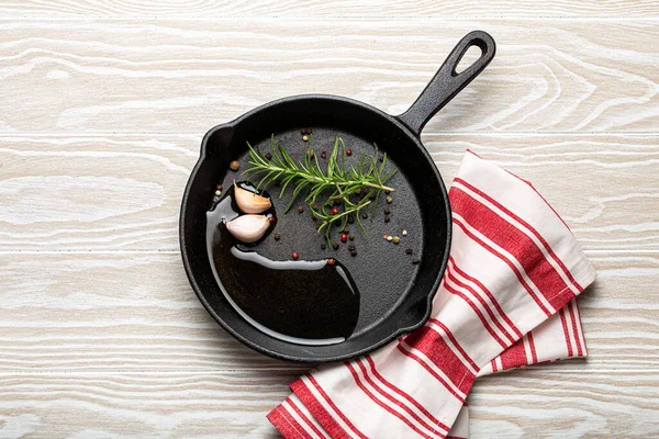 Padella nera in ghisa con rosmarino, aglio, pepe, olio — Foto Stock