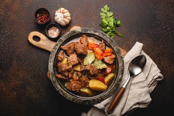 野菜と肉のビーフシチューと素朴な金属鍋の上からの眺め — ストック写真