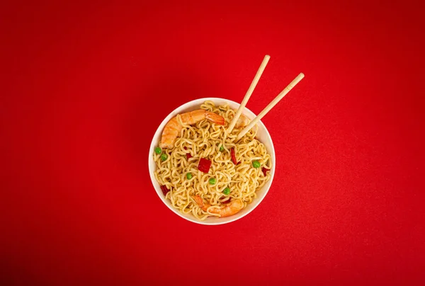 Asian noodles with shrimps in bowl, minimal red background — Stock Photo, Image