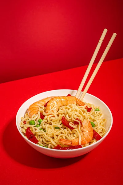 Asian noodles with shrimps in bowl, minimal red background — Stock Photo, Image