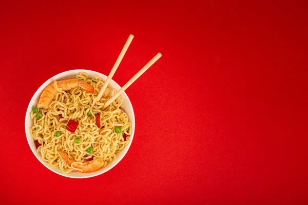 Asian noodles with shrimps in bowl, minimal red background — Stock Photo, Image