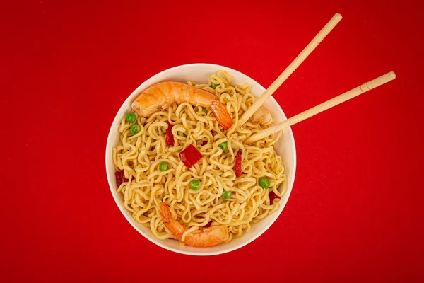Asian noodles with shrimps in bowl, minimal red background — Stock Photo, Image