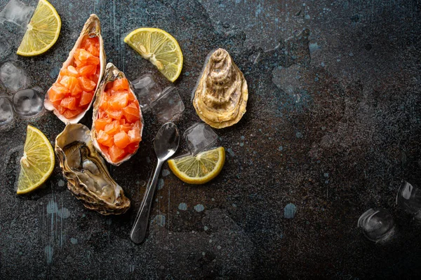 Salmon tartare raw chopped served in oyster shells top view on stone background — Stock Photo, Image
