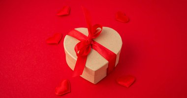 Kalp şeklinde hediye kutuları, kırmızı arka planda fiyonk, Sevgililer Günü