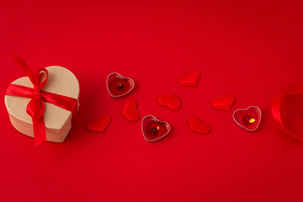 Saint Valentine top view composition with gift box, candles, hearts on red background — Stock Photo, Image