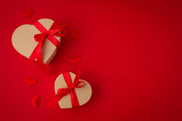 Kaksi käärittyä lahjapakkausta sydämen kunnossa punaisella taustalla, Saint Valentine päivä — kuvapankkivalokuva