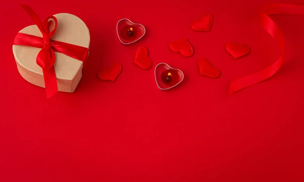 Szent Valentin top view kompozíció ajándék doboz, gyertyák, szív a piros háttér — Stock Fotó