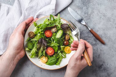 Man eating vegetarian vegetables healthy salad with red and yellow cherry tomatoes