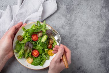 Man eating vegetarian vegetables healthy salad with red and yellow cherry tomatoes