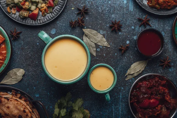 Indiano saudável Ayurveda beber manga lassi em duas xícaras em mesa de concreto rústico — Fotografia de Stock