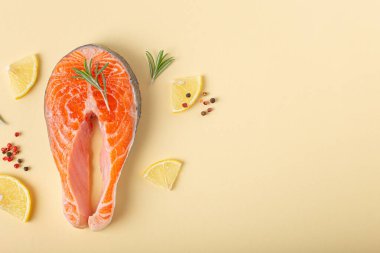 Çiğ taze balık somon bifteği yukarıdan bej renkli pastel arka plan manzaralı