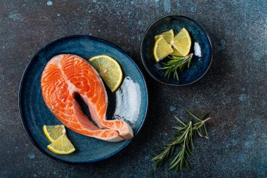 Çiğ balık somon bifteği. Koyu renkli, taştan arka planda.