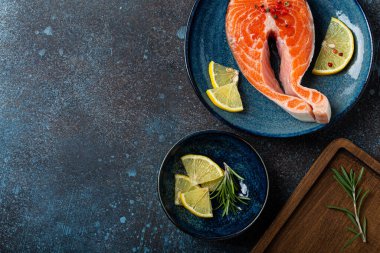 Çiğ balık somon bifteği. Koyu renkli, taştan arka planda.