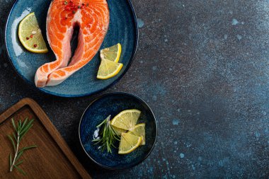 Çiğ balık somon bifteği. Koyu renkli, taştan arka planda.