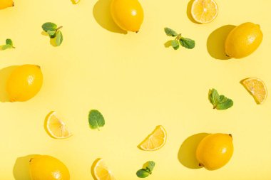 Minimum bej arkaplanda naneli limonlar. Parlak güneş ışığı ve sert gölge desenli.