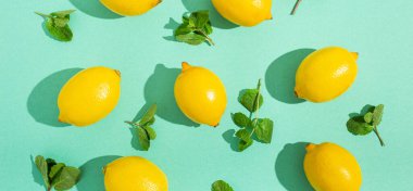 Minimum mavi arka planda naneli limonlar. Güneş, arka planda sert gölgeler bırakıyor.