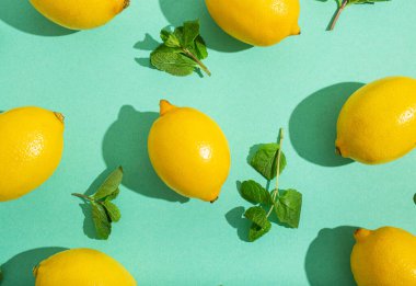 Minimum mavi arka planda naneli limonlar. Güneş, arka planda sert gölgeler bırakıyor.