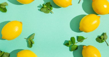 Minimum mavi arka planda naneli limonlar. Güneş, arka planda sert gölgeler bırakıyor.