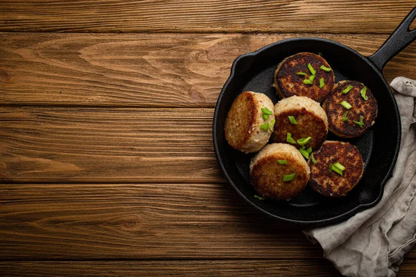魚、鶏や黒キャスト鉄フライパンフライパンのフライパンに肉から自家製のカツレツ — ストック写真