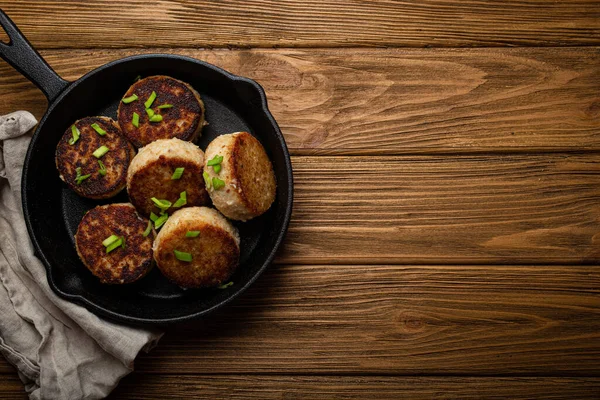 Hausgemachte Schnitzel aus Fisch, Huhn oder Fleisch auf schwarzer gusseiserner Pfanne — Stockfoto