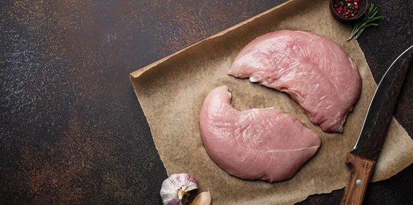 Türkiye biberiye, sarımsak ve baharatlı fırın kağıdı üzerine çiğ fileto koyuyor