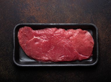 Siyah plastik kapta sığır eti, çiğ biftek.