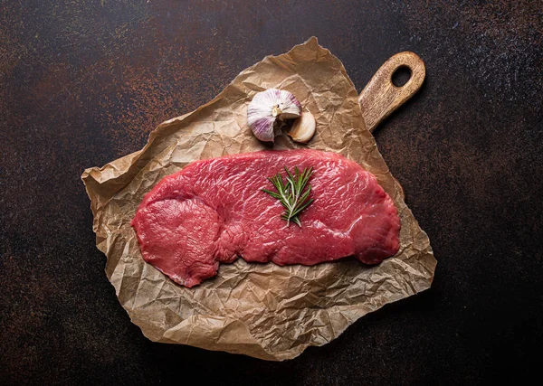Nötkött mager rå filébiff på bakplåtspapper med rosmarin, vitlök och kryddor — Stockfoto
