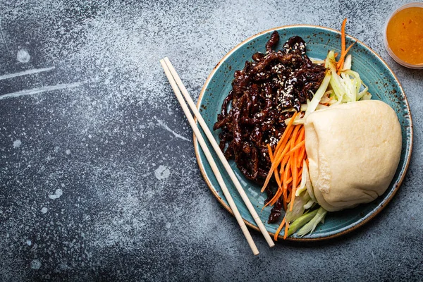 Китайська традиційна страва солодка і кисло-смажена глазурована свинина з овочами і пропарені булочки бао — стокове фото
