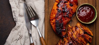 Izgara hindi ya da kırmızı soslu tavuk filetosu. Ahşap kesme tahtasında servis edilip dilimlenmiş.