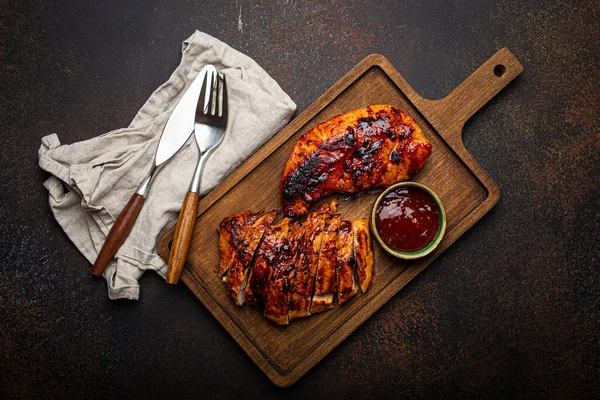 Grilled turkey or chicken fillet with red sauce served and sliced on wooden cutting board — Stock Photo, Image