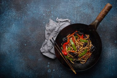 Siyah tava fotokopi alanında sebzeli erişte kızartır.