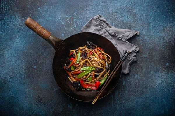 Asiatiska steknudlar med grönsaker i svart wok pan — Stockfoto