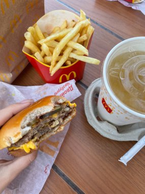 Rusya, Barnaul, 29 Ağustos 2021: Arkadan ısırılmış bir çizburger, Barnaul 'daki bir McDonald' s fast food restoranından alınmış patates kızartmasıdır..