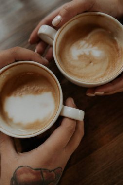 Yakın planda iki fincan kahve. Bir adam ve bir kız kahve içiyorlar, fincanlar yakın plan..